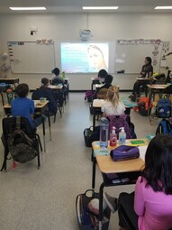 Students praying the rosary from their desks.