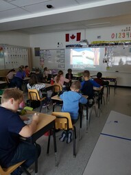 Students praying the rosary from their desks.