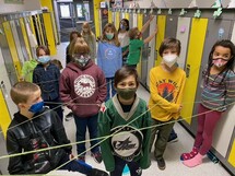 Grade four students standing in the web of strings.